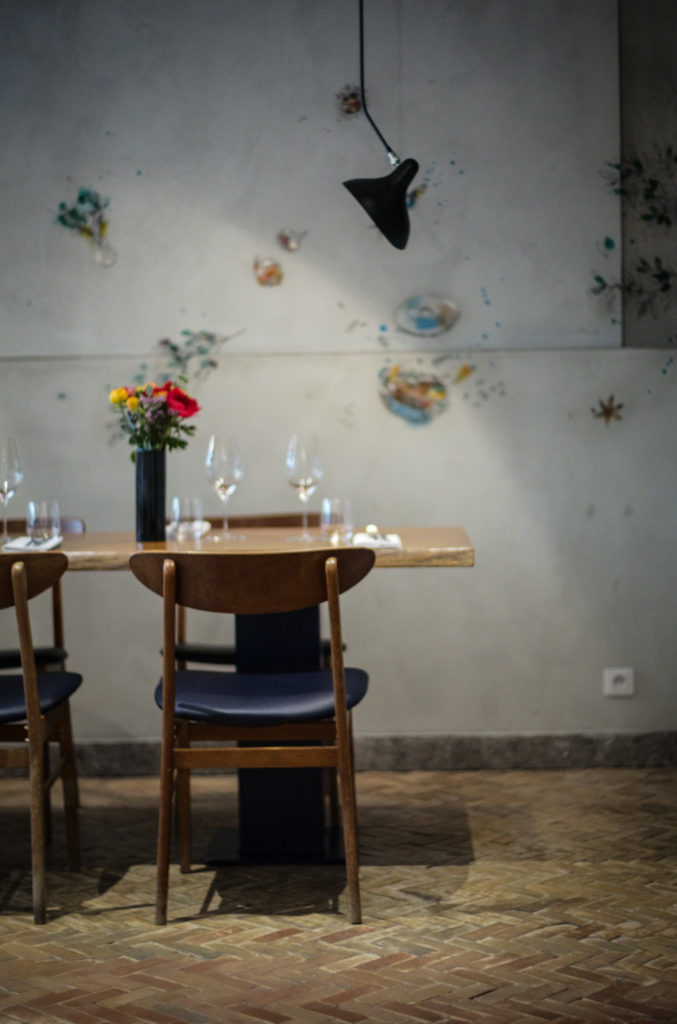 Table dressée et bouquet de fleurs contre un mur de béton