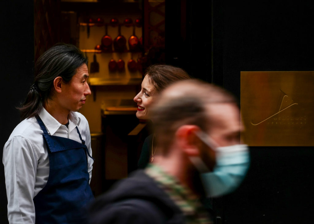 Équipe de salle devant l’entrée d’un restaurant