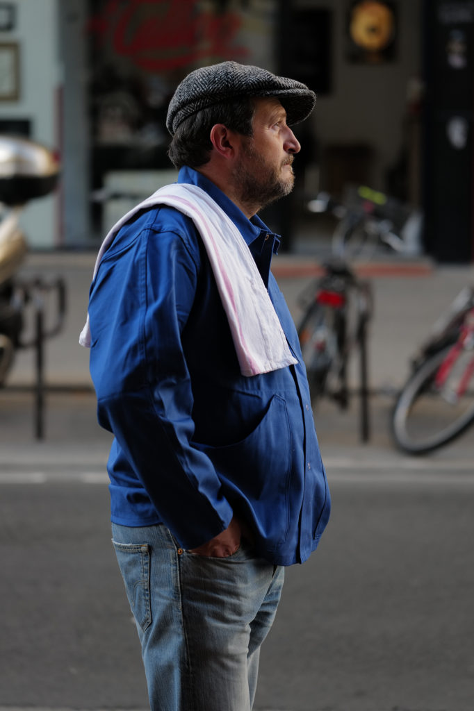 Portrait dans la rue, veste bleue et torchon sur l’épaule