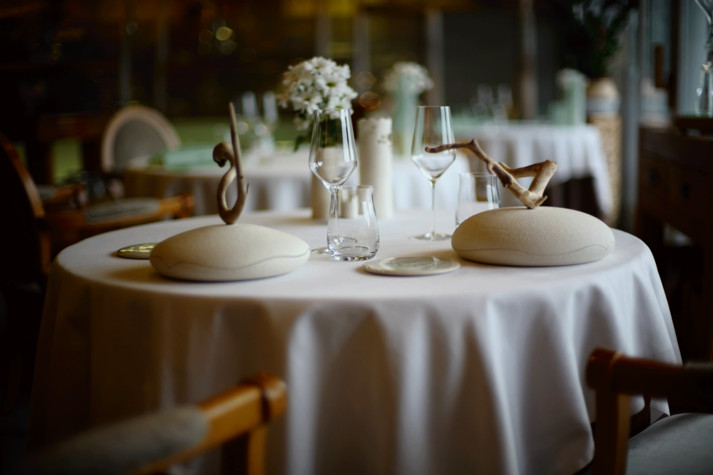 Tables rondes nappées de blanc et cloches de service