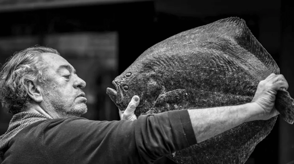 Le chef Bruno Verjus tenant un turbot, portrait en noir et blanc