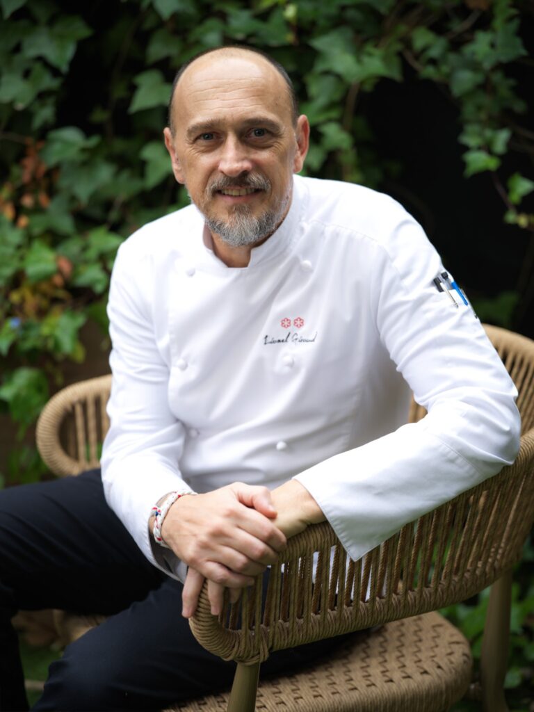 Portrait du chef Lionel Giraud dans un jardin, veste aux deux étoiles