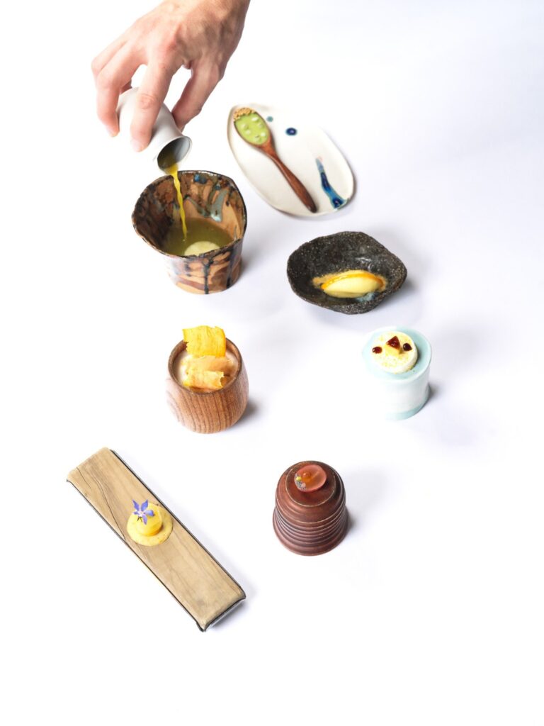Bouchées dans des contenants de bois et de céramique, jus versé, AM par Alexandre Mazzia