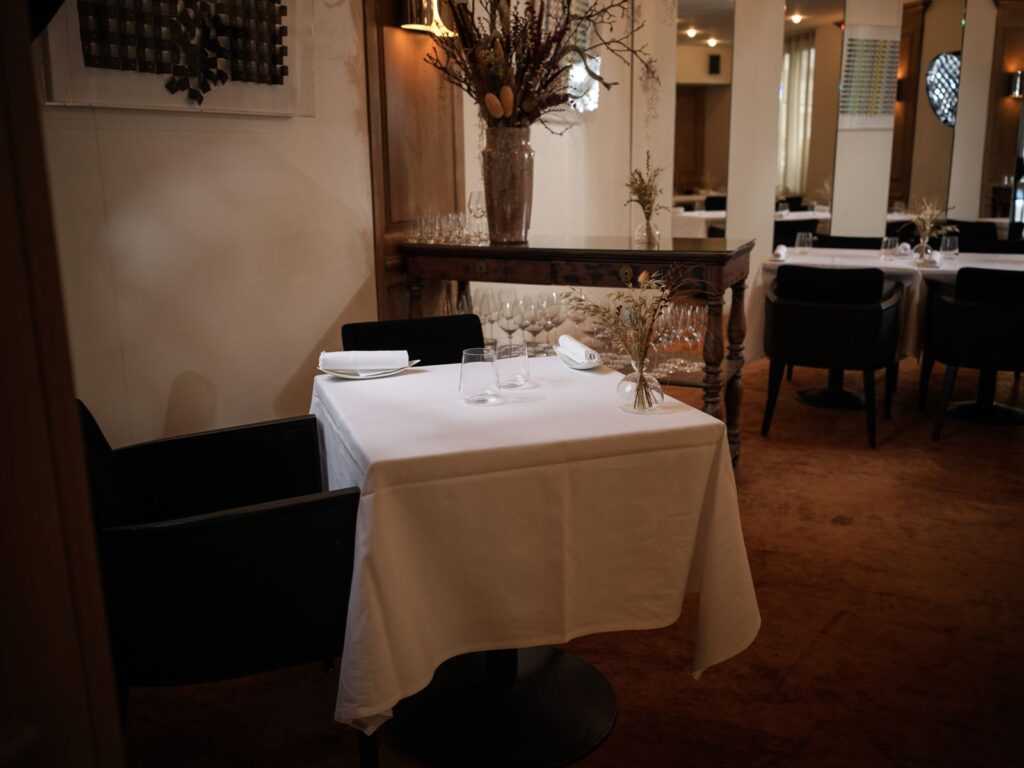 Salle du restaurant Zostera, tables nappées de blanc